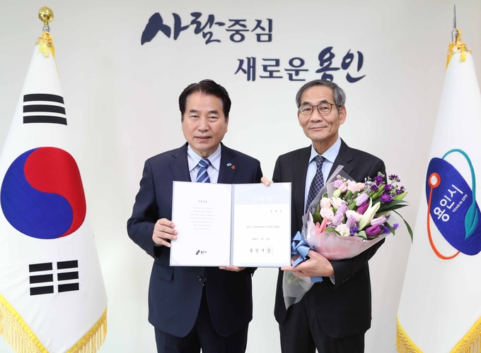 백군기 용인시장이 김춘식 용인시인재육성재단 이사장에게 임명장을 수여한 후 기념사진을 찍고있다.