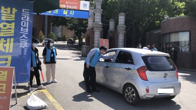 용인송담대학교 정문 발열체크 검사소를 운영 중인 최성식 총장