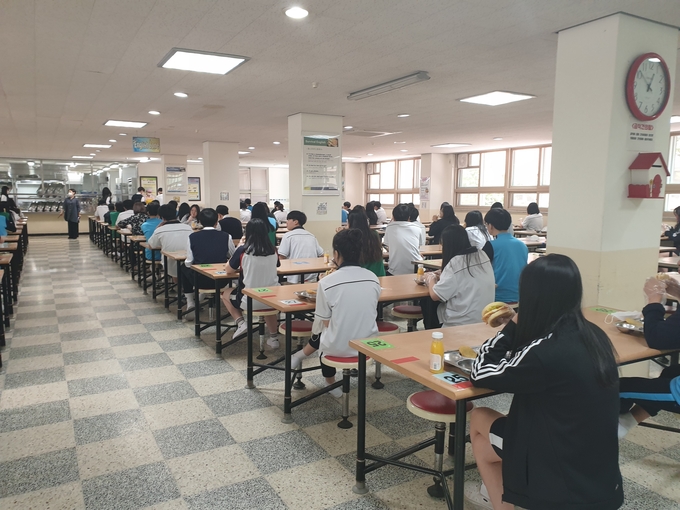 안전 거리를 준수하며 한쪽 방향으로 앉아 급식하는 모습